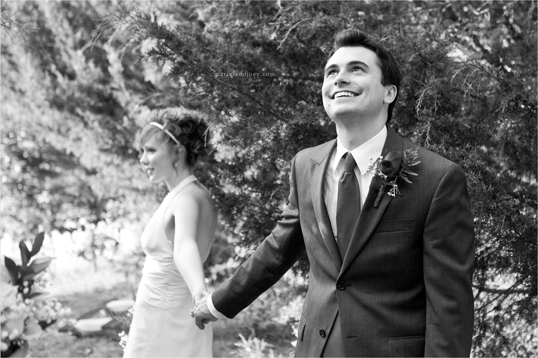 Bride and Groom holding hands before outdoor ceremony without seeing each other